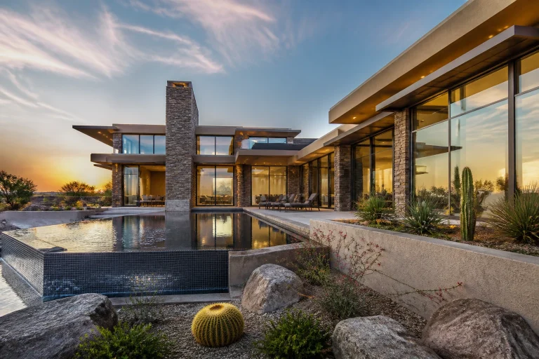 Contemporary desert residence exterior at sunset with pool.